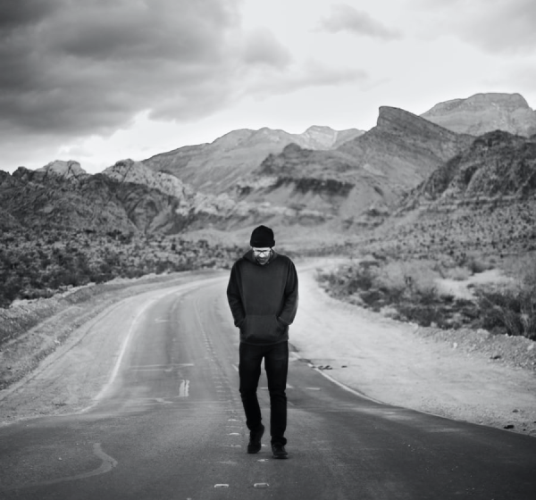 lonely man walking on the road in mountains